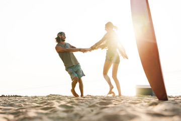 Photo of joyful caucasian couple smiling and spinning