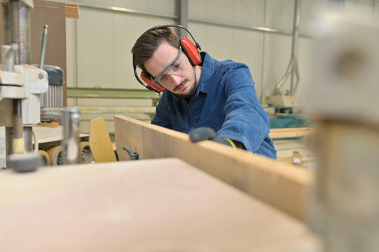 Apprentice working wood in carpentry workshop