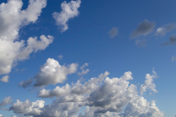Naklejka na ściany i meble White cumulus clouds on blue sky.