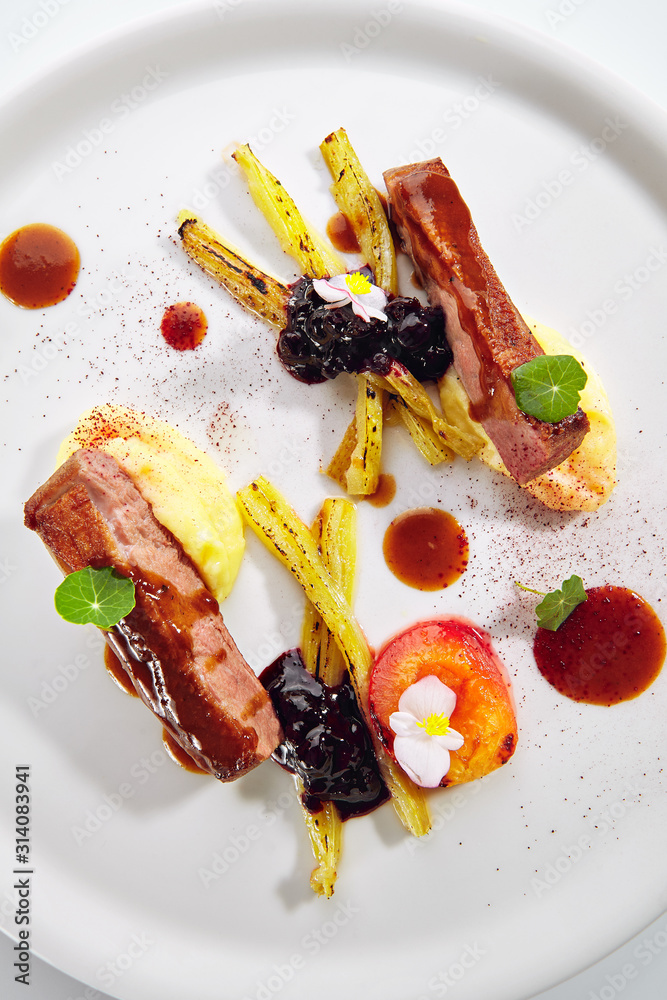 Poster fried duck breast with baked plum and glazed rhubarb isolated