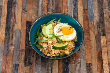 Wok rice cooked with soy sauce, vegetables and chicken pieces.