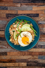 Wok rice cooked with soy sauce, vegetables and chicken pieces.