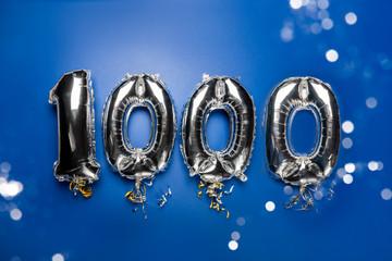 Balloon Bunting for celebration Happy 1000th Anniversary made from Silver Number Balloons on blue...