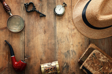 Concept image of investigation or private detective. Fedora hat, magnifying glass and vintage items...