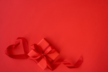 Valentines day greeting card with gift box and beautiful ribbon on red background