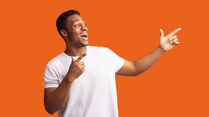 Excited black guy pointing two fingers aside