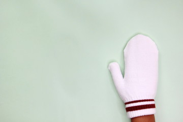 One hand in white mitten isolated on a light background