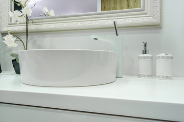 Soap and shampoo dispensers near Ceramic Water tap sink with faucet in expensive loft bathroom