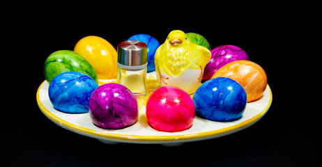 yellow clay chick in the middle of a plate of Easter eggs