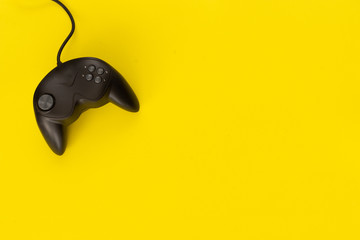 Black console gamepad of video game on yellow background. concept of fun and strategy. © Cautivante.co