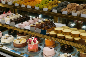 sweets and cakes on display in bakery shop -