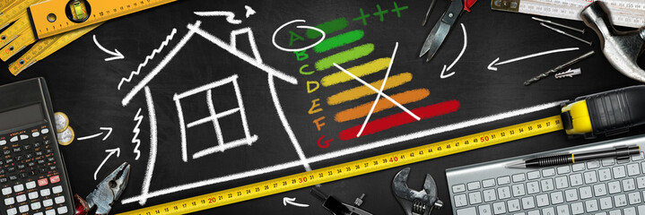 House Energy Efficiency Rating. Blackboard with chalk drawing, work tools, calculator and a...
