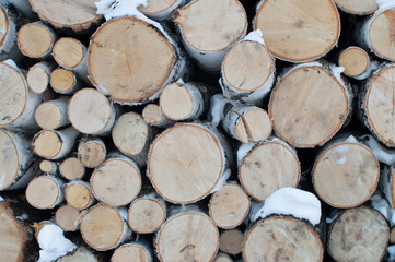Fototapeta premium Woodpile of firewood, powdered with snow. Decorative texture.