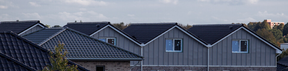 a row of houses with a black tiled roof