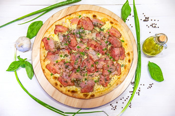 pizza with bacon, green onions and olive oil on a white background, flat lay