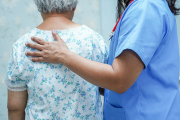 Asian nurse physiotherapist doctor touching Asian senior or elderly old lady woman patient with...