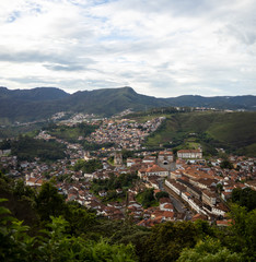 Fototapeta na wymiar Early morning panoramic view of colonial mining city centre Ouro Preto in Minas Gerais, Brazil, with surrounding mountains in the background seen from a high altitude and large distance