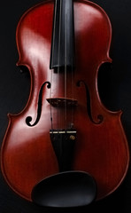 Front side of violin put on black canvas,blurry light around