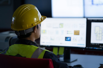 Industrial Engineering works in front of monitoring screen in the production control center. technology concept.