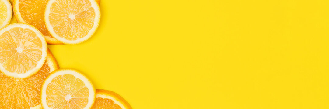 Juicy citrus on a yellow background. Bright vitamin photo. Copy space, web-banner format.
