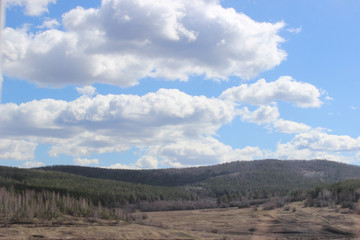 blue sky with white clouds over the fields
