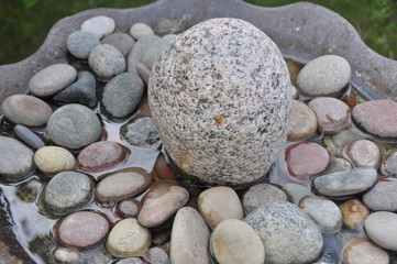Granite Fountain Stone Surrounded by Wet Pebbles