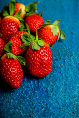 Ripe and juicy strawberries on the dark rustic background. Selective focus. Shallow depth of field.