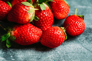 Ripe and juicy strawberries on the dark rustic background. Selective focus. Shallow depth of field.