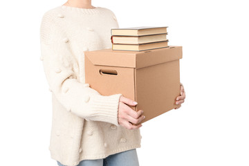 Close up hands of student or office worker woman holding cardboard full of books with  copy space for handwriting. Moving day concept. Delivery of online order. packing of textbooks