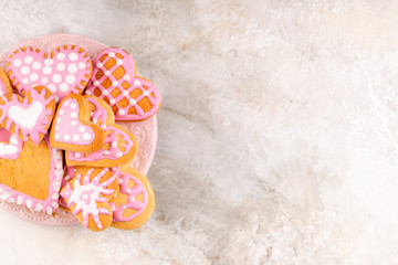 Pink Plate with Homemade Glazed Decorated Heart Shaped Cookies for Valentines Day on Marble Background. Copy Space, Top View
