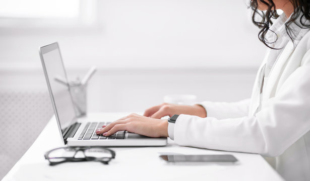 Cropped image of hispanic girl working on laptop