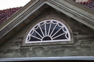 Old wood house window details with half round figure.