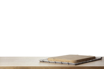 Folded kitchen towel and cutting board on wooden table. Space for design