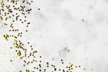 Holiday background with gold star confetti on blue background