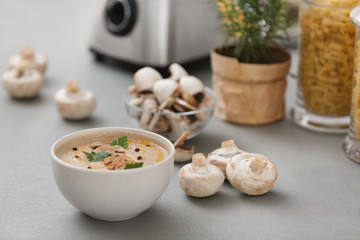 Delicious cream soup with mushrooms on grey table