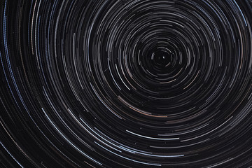 Long exposure starry sky, twisted tracks of stars.