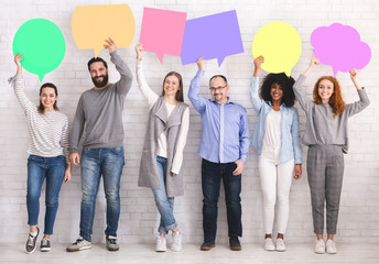 Naklejka premium Diverse people holding colorful speech bubbles, free space