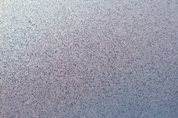 Ice and frost on a window pane in winter. Crystal surface of frozen water. Weather forecast: cold, frost, cooling. Abstract blue background or wallpaper. Harsh season