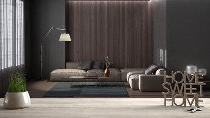 Wooden table, desk or shelf with potted grass plant, house keys and 3D letters making the words home sweet home, over modern living room with sofa, interior design, blur background