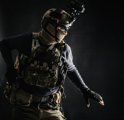 Special operations fighter in helmet with night-vision, thermal imaging device, load carrier...