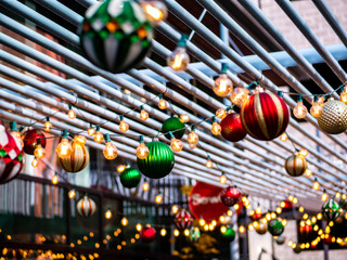 Christmas ornaments hanging from metal trellis 