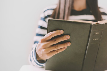 Woman holding the open bible in hands with copy space.