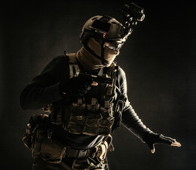 Special operations fighter in helmet with night-vision, thermal imaging device, load carrier...