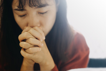 Soft focus Woman are praying and thanks to the Lord, girl prayer,copy space,sunday morning, devotion concept.