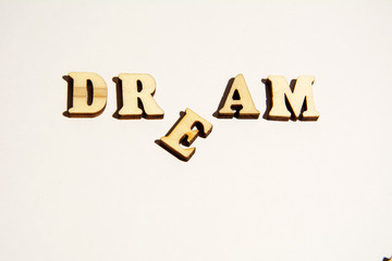 Obraz premium Word Dream written on white background close-up. Broken dreams.
