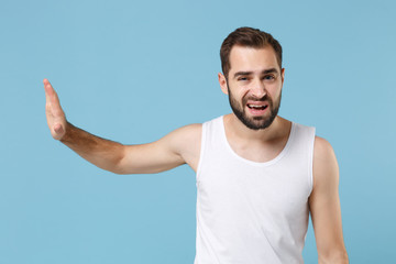 Fototapeta premium Close up bearded young man 20s years old perfect skin wearing white shirt isolated on blue pastel wall background, studio portrait. Skin care healthcare cosmetic procedures concept. Mock up copy space