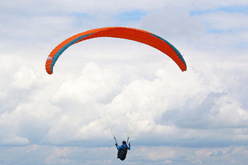 Paraglider flying wing in a cloudy sky	