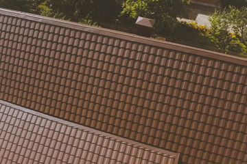 Brown metal tile on the roof of the house. Corrugated metal roof