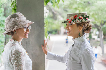 two young friends talking and wearing vintage hats