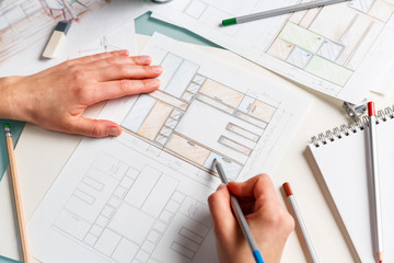 Designer works on color pencil drawing of a furniture.